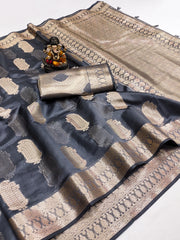 Black and gold saree with a decorative item on a white background