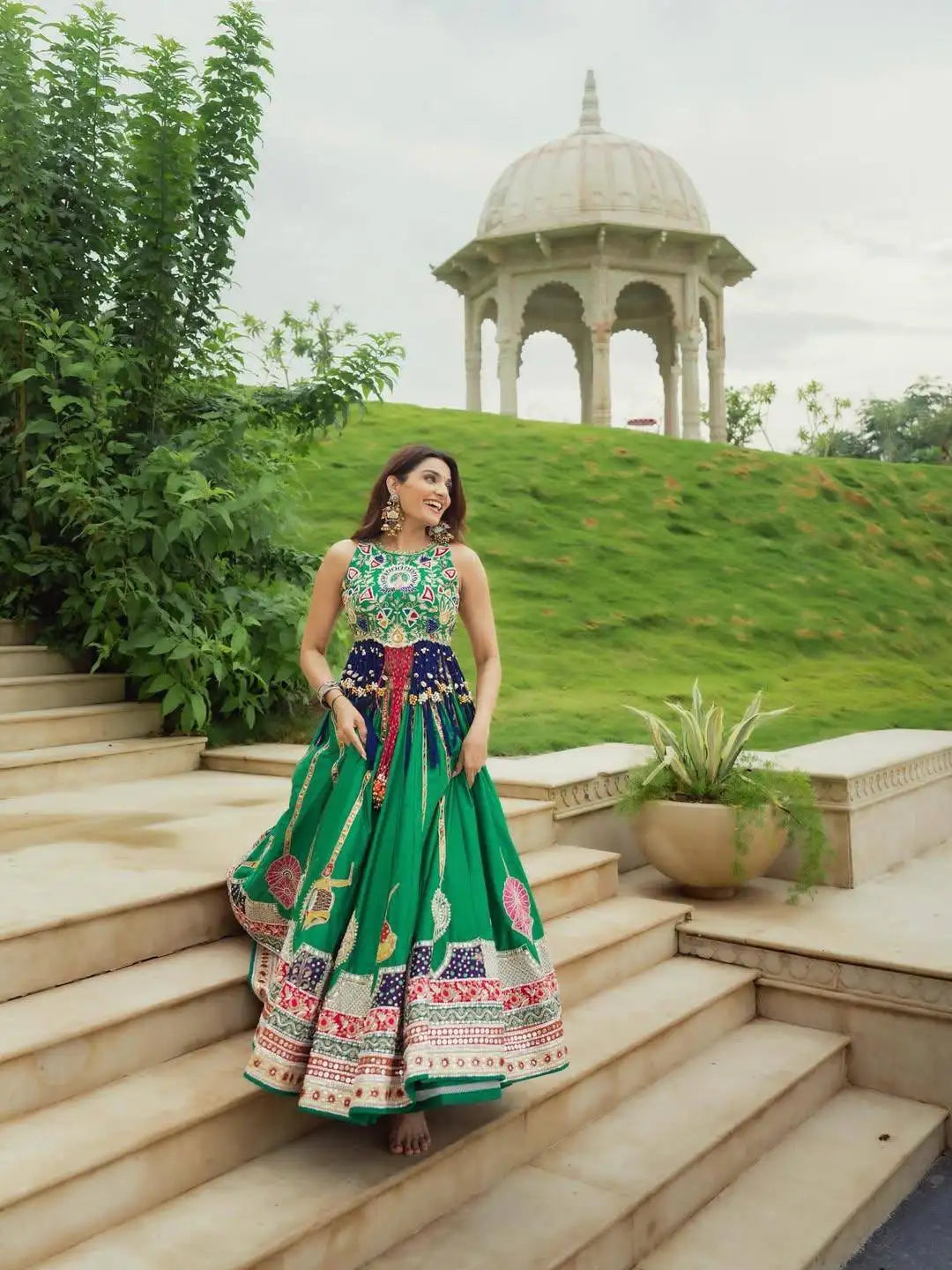 Green Digital Print Lehenga walking down garden steps near domed pavilion
