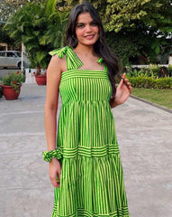 Woman wearing a green and white striped dress outdoors.