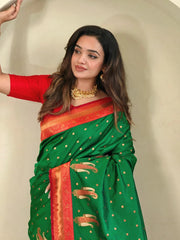 Woman wearing a green and red saree with gold accents against a neutral background