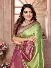 Woman wearing a green and pink saree with a floral background