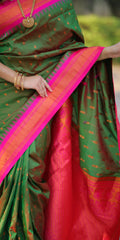 Green and red saree with gold patterns, held by a person.