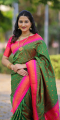 Woman wearing a green and pink saree with a blurred outdoor background