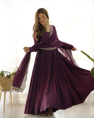 Woman wearing a long purple dress with a matching shawl indoors.