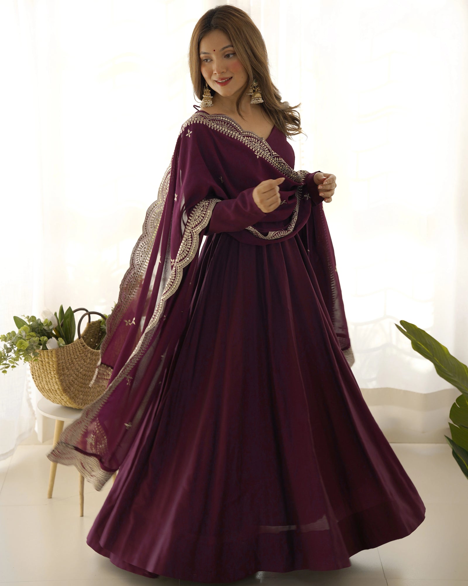 Woman wearing a burgundy traditional outfit with a white background
