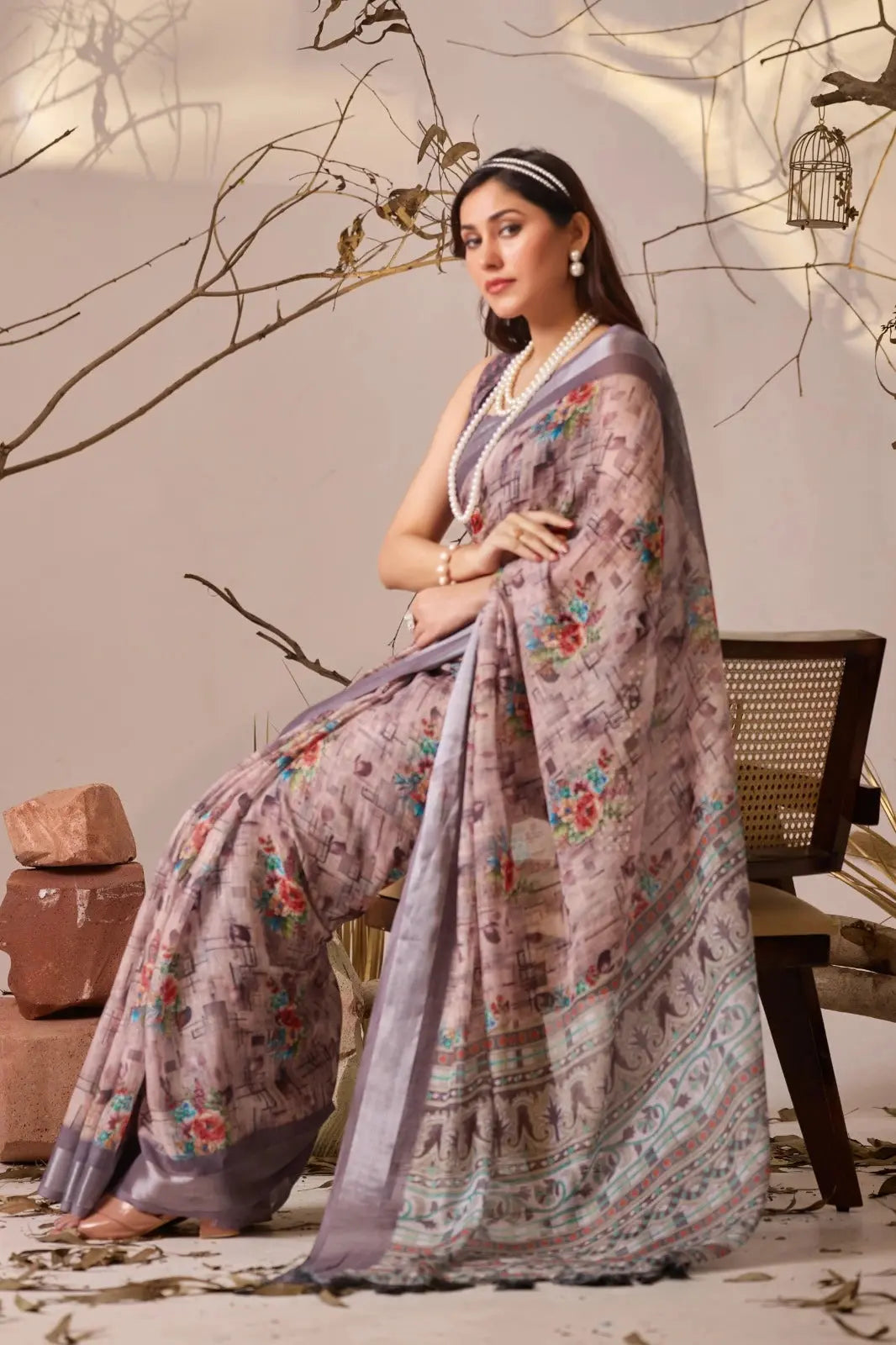 Seated full view of Dusty Mauve Digital Floral Print Saree showing tribal art print pallu and floral body