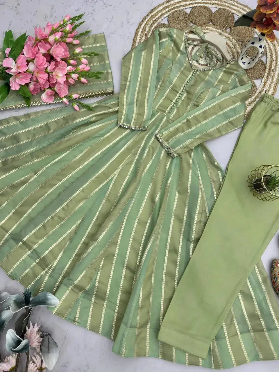 Full flat lay of soft pastel green mirror work suit set with dupatta, pants and footwear