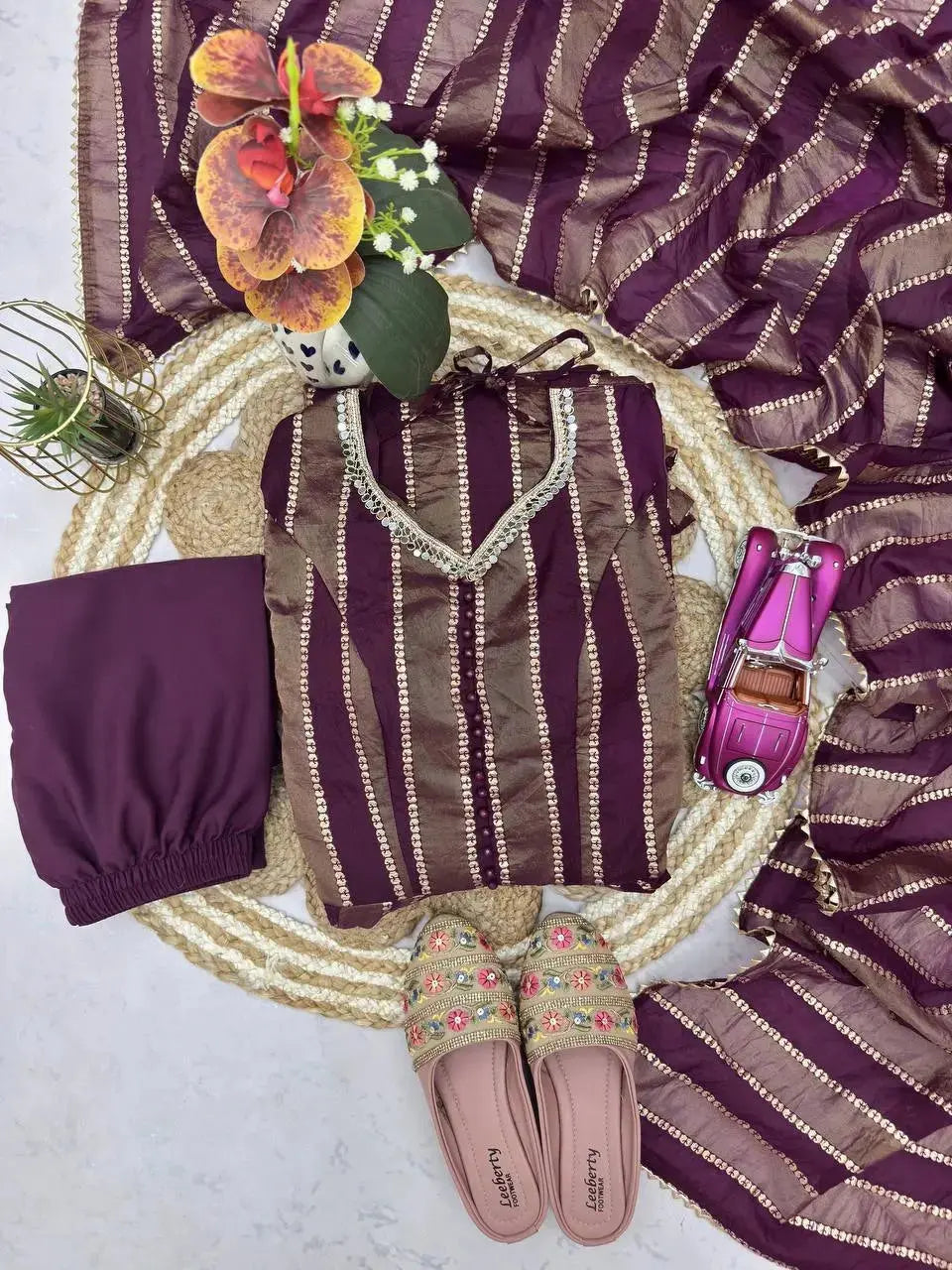 Full flat lay of wine mirror work suit set with dupatta, pants and footwear