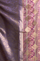 Close-up of patterned fabric with intricate designs on a purple and pink background