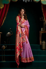 Woman in a traditional saree standing on steps with a dark background