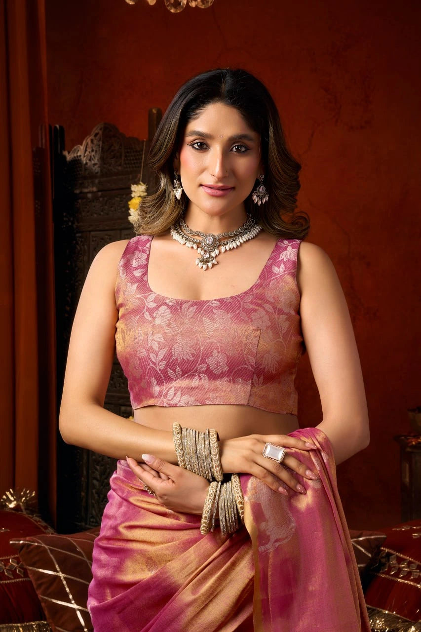 Woman in a pink traditional outfit with jewelry against a warm-toned background