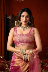 Woman in a pink traditional outfit with jewelry against a warm-toned background