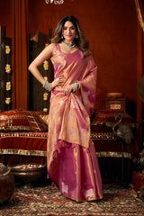 Woman in a pink saree standing in an ornate room with decorative elements.