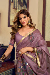 Woman wearing a traditional saree with intricate designs in an indoor setting.