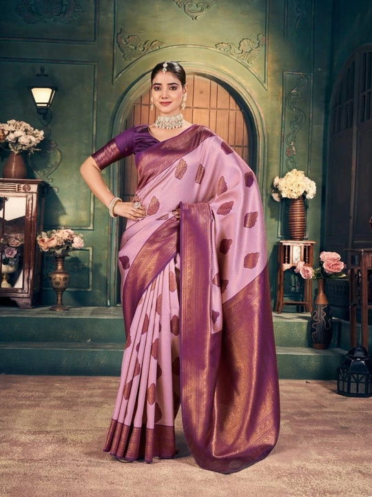 Woman in a traditional saree standing in an ornate room with decorative elements.