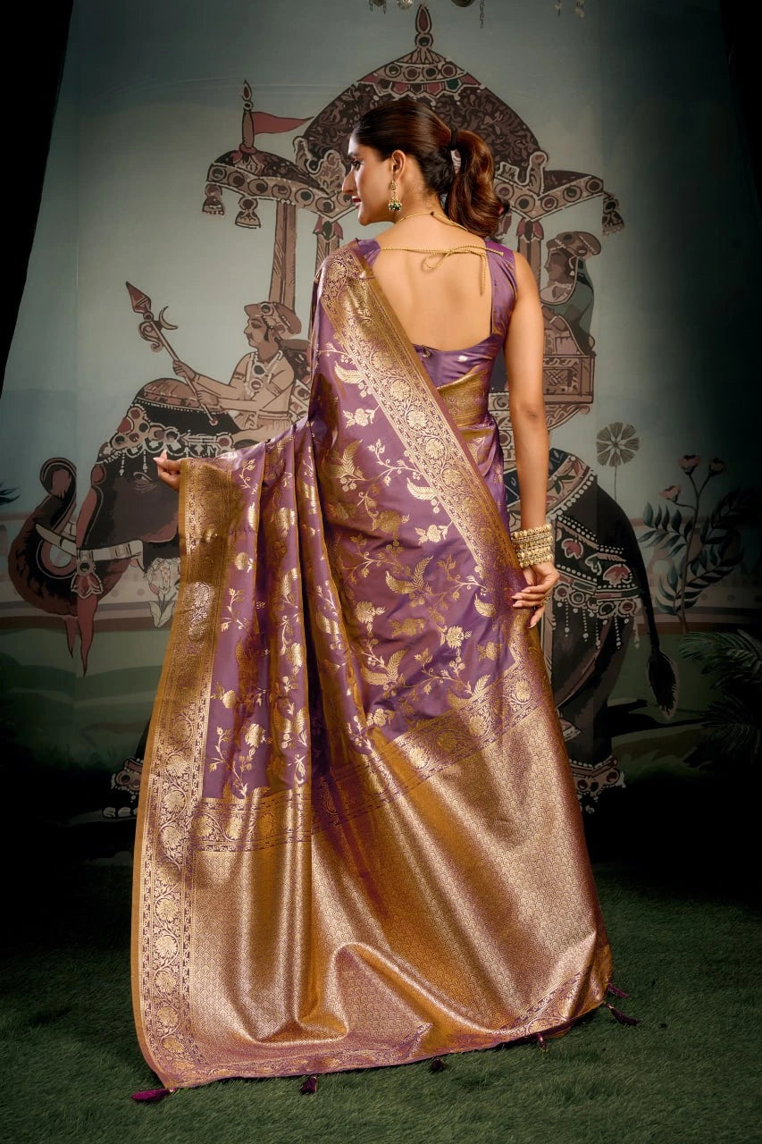 Woman in a traditional purple and gold saree with a decorative backdrop