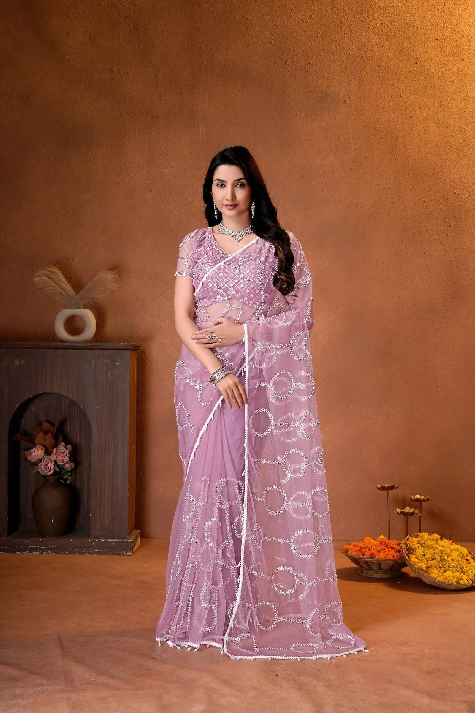 Elegant mauve pink designer saree featuring shimmering sequins embroidery and intricate handcrafted detailing for a graceful festive look.