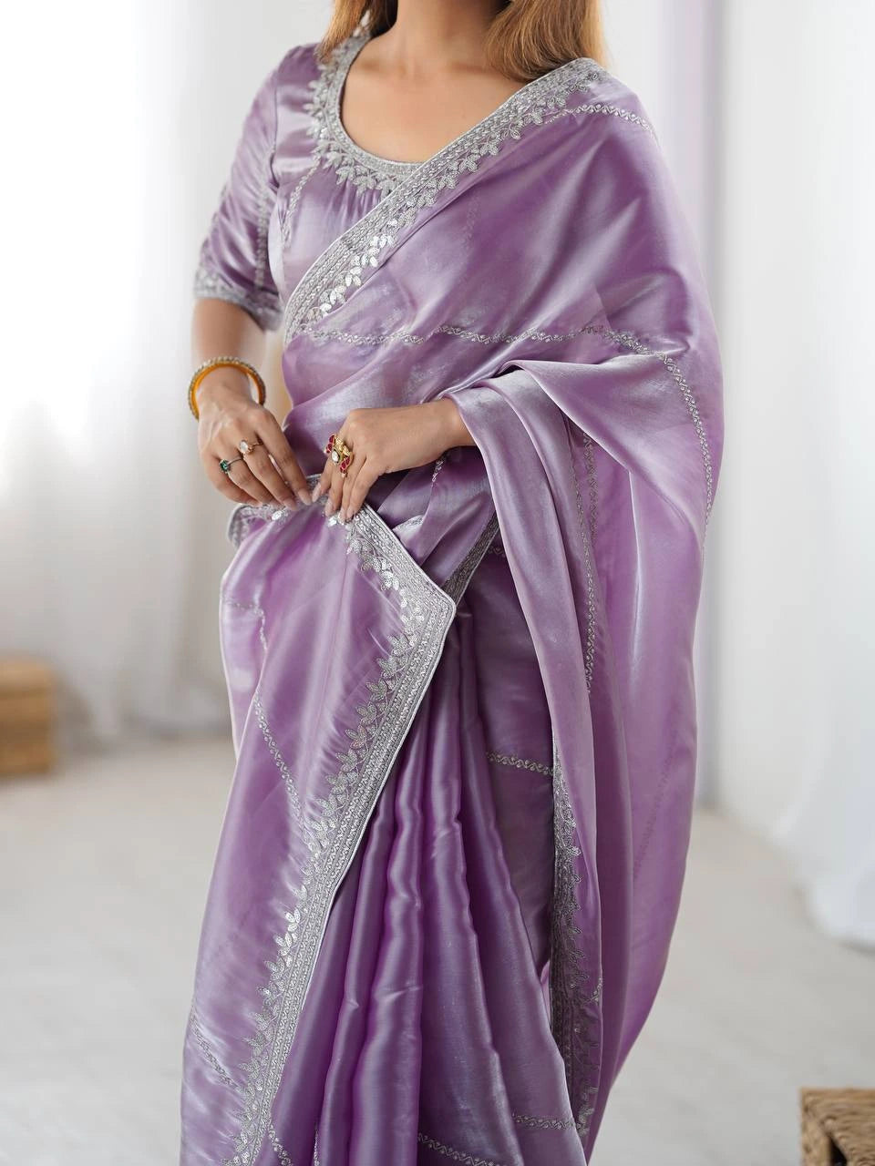 Purple saree with silver border worn by a person on a white background
