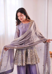 Woman wearing a light purple embroidered outfit with a matching dupatta in a well-lit room.