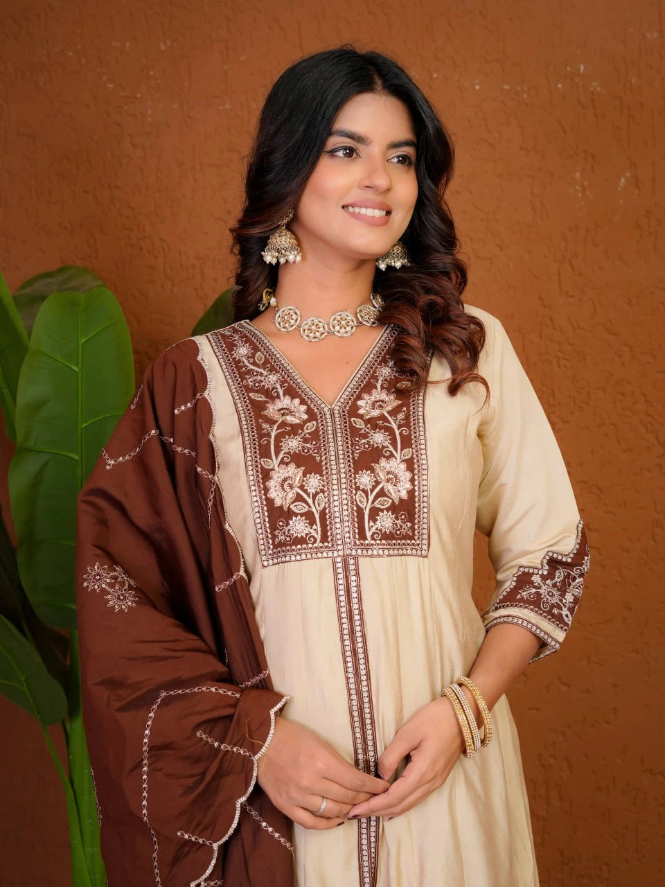 Woman wearing a traditional outfit with embroidery against a brown background