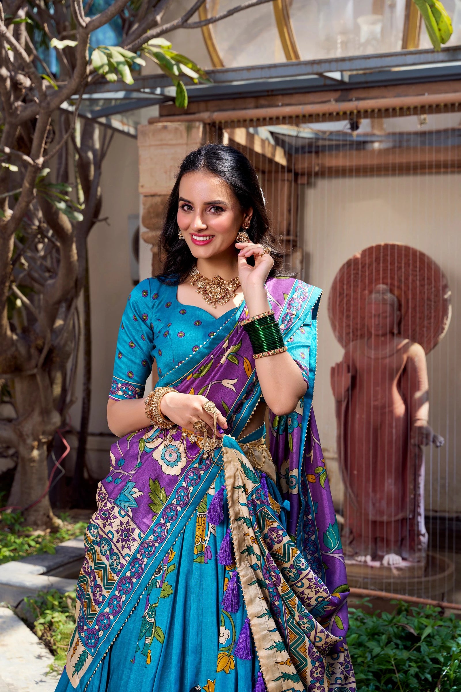 Elegant sky blue Kalamkari printed saree with purple floral pallu and artistic traditional border.