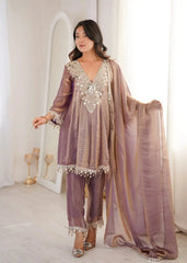 Woman wearing a traditional outfit with a shawl in a softly lit room.