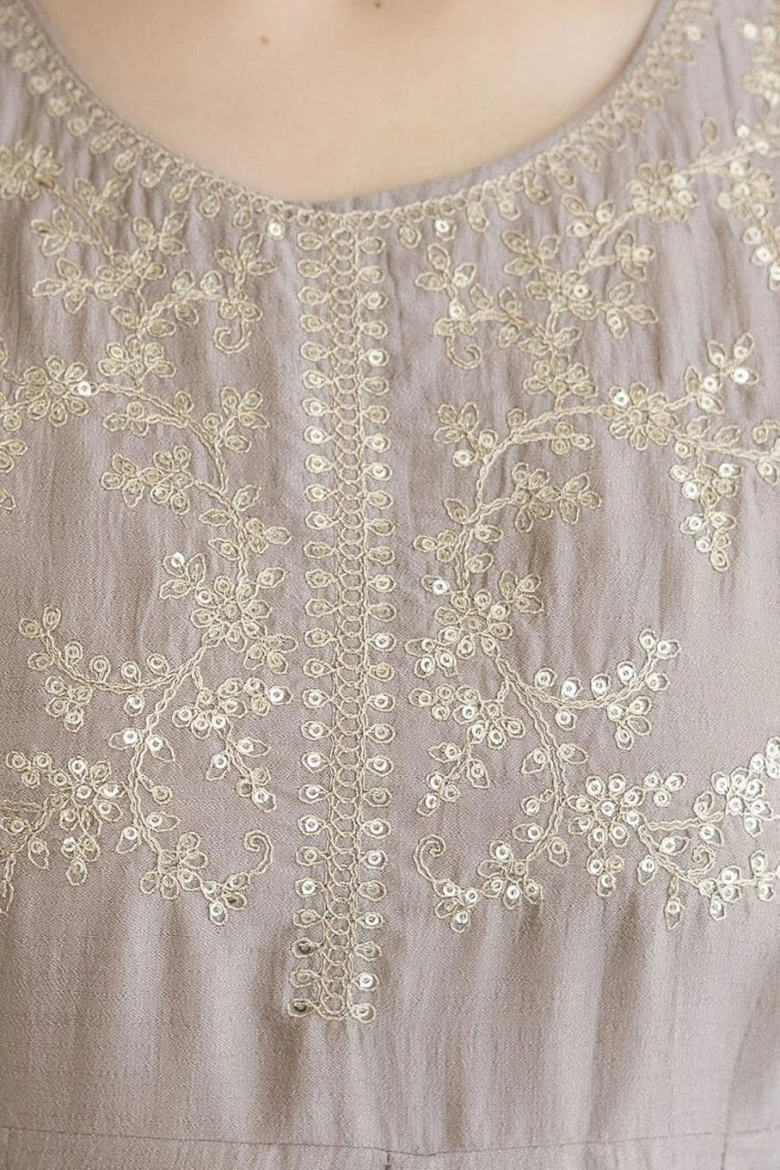 Close-up of a beige embroidered garment with floral patterns