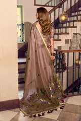 Woman in a saree walking up a staircase in an indoor setting