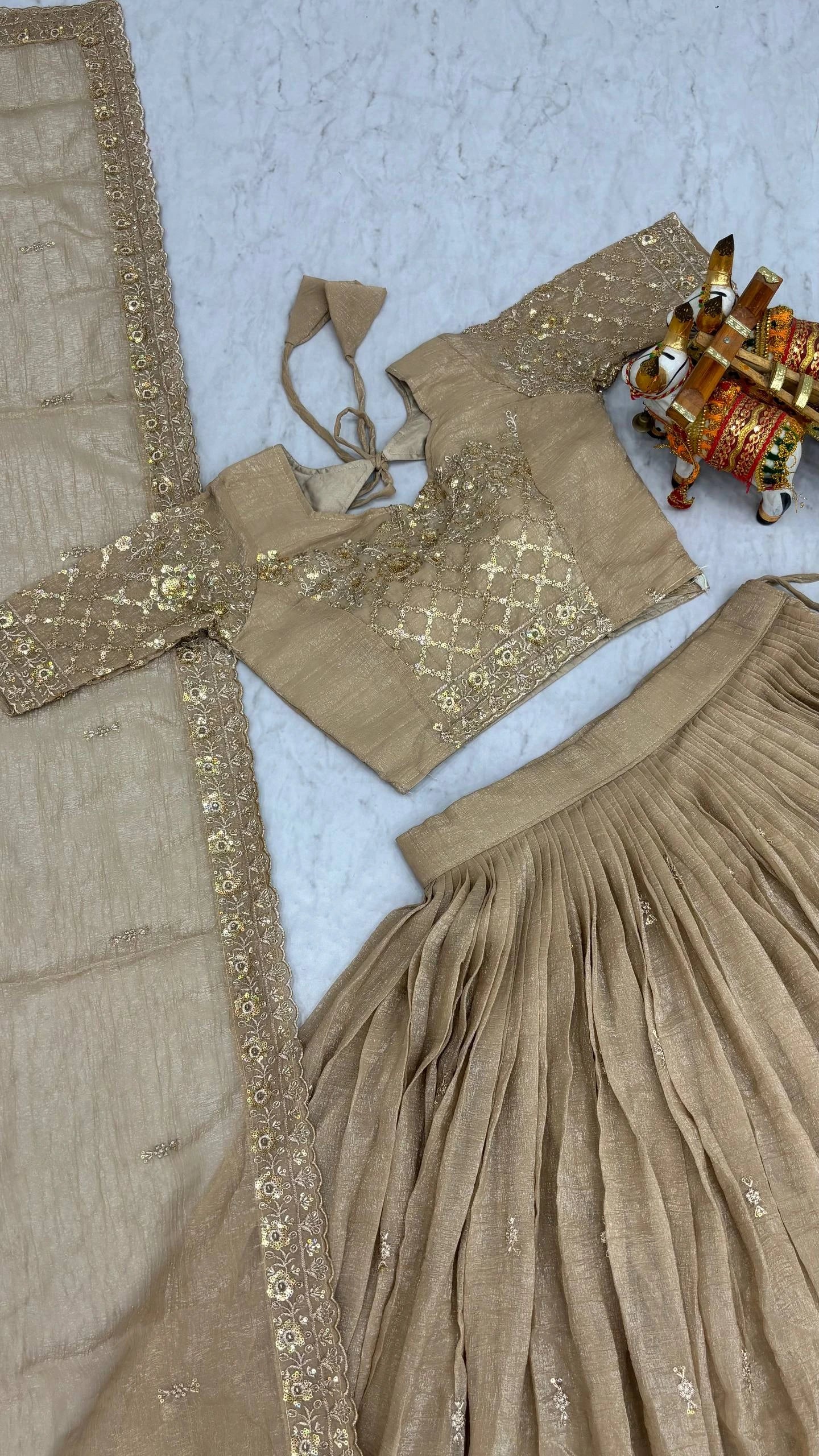Beige traditional outfit with gold embroidery on a light blue background
