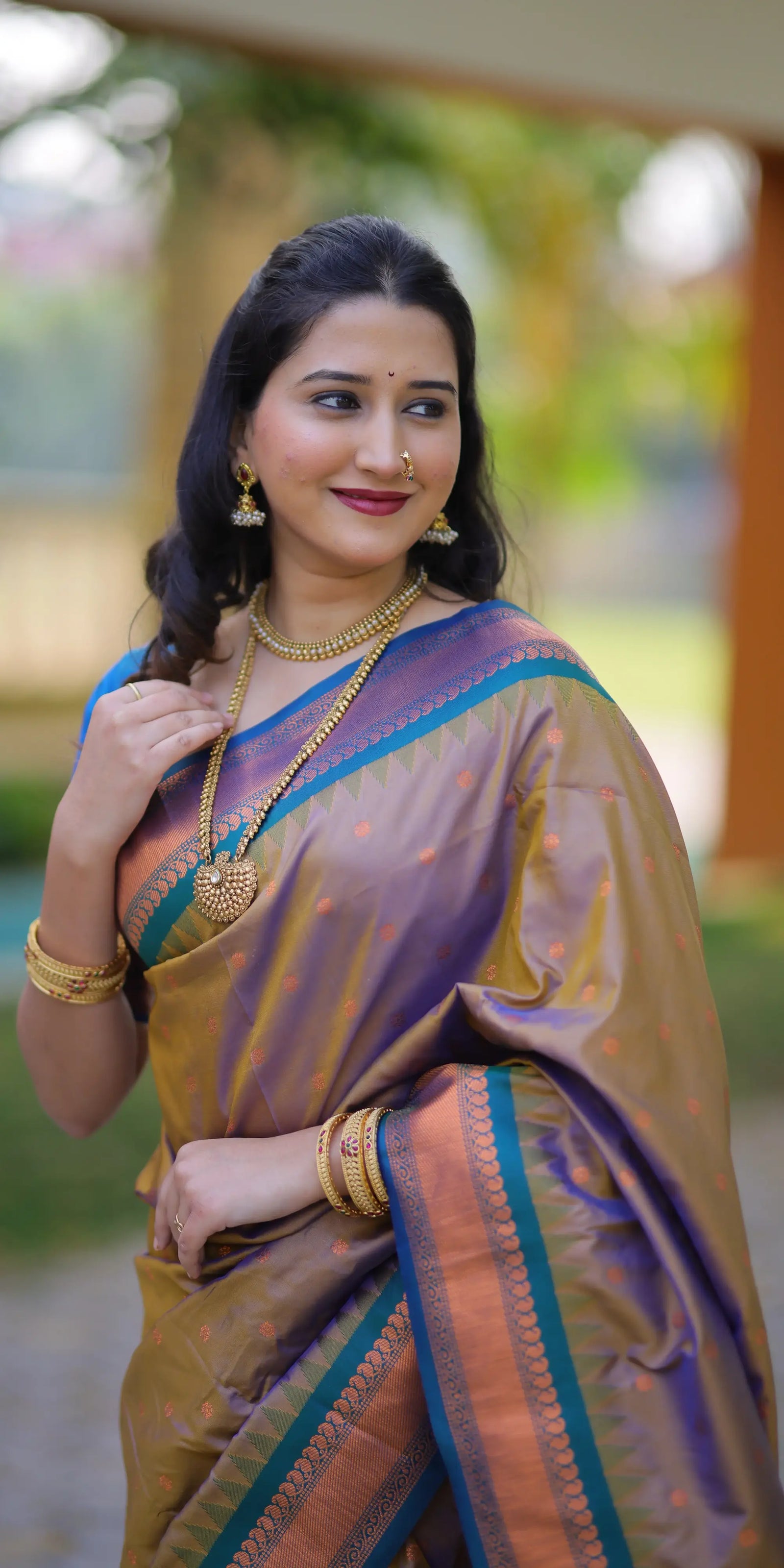 Woman in a traditional saree with jewelry outdoors
