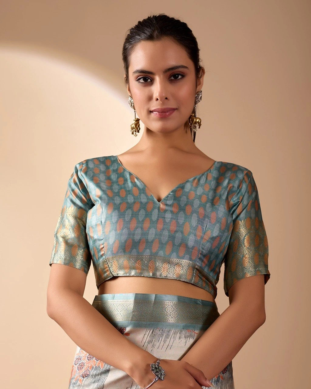 Woman wearing a patterned blouse against a beige background