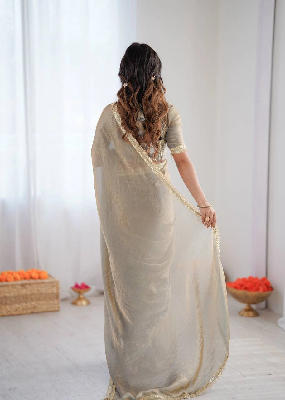 Woman wearing a beige saree with a white background