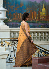 Woman in a yellow saree standing on a balcony with a scenic painting in the background