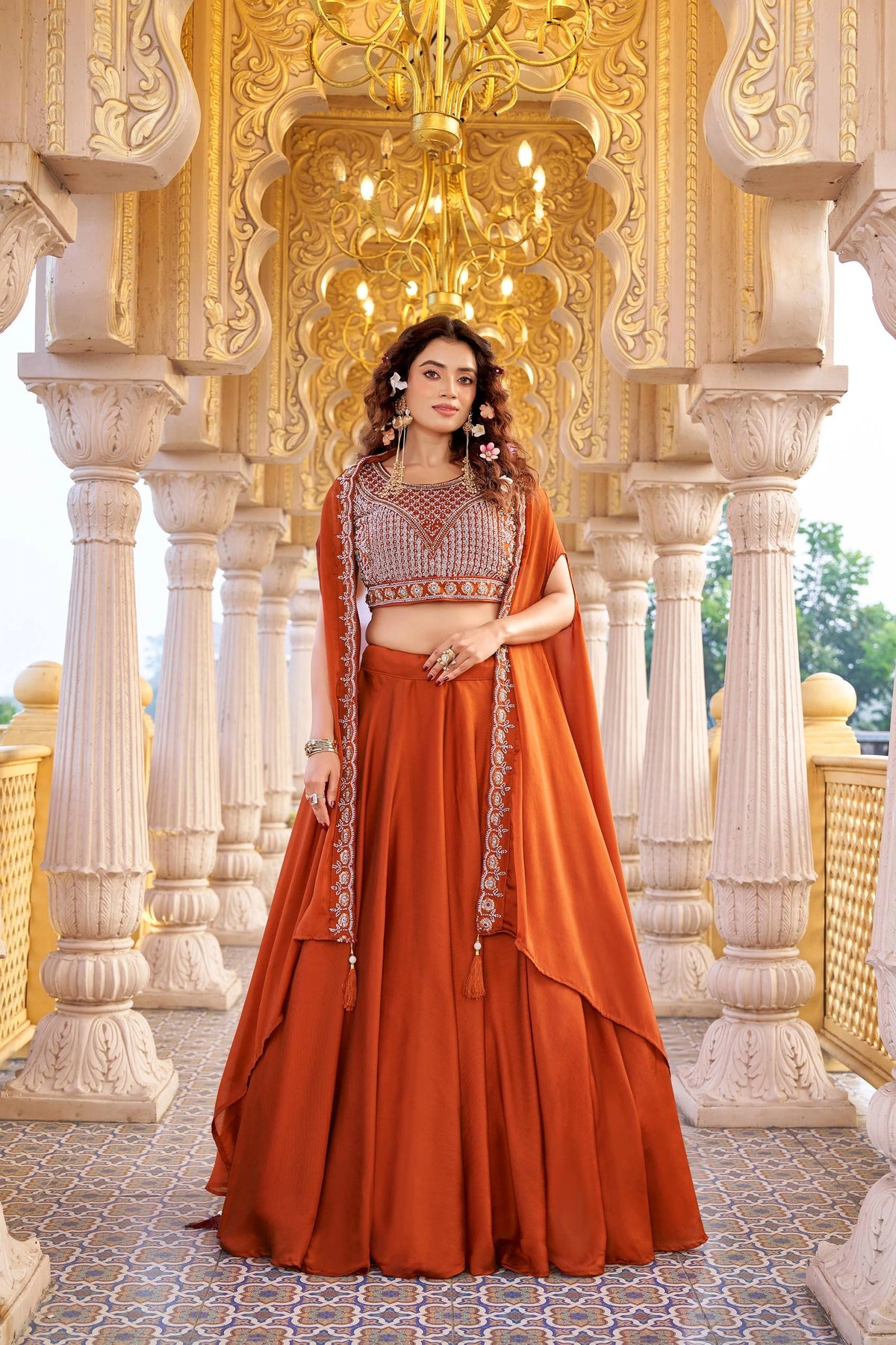 Woman in traditional orange outfit with intricate patterns in a decorative setting