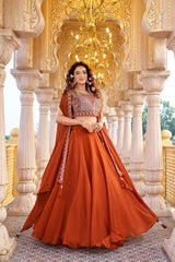 Woman in a traditional orange outfit standing in an ornate architectural setting.