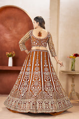 Woman wearing a traditional embroidered lehenga in a decorated room with flowers.