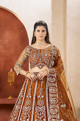 Woman in an orange and gold embroidered traditional outfit with a decorative background