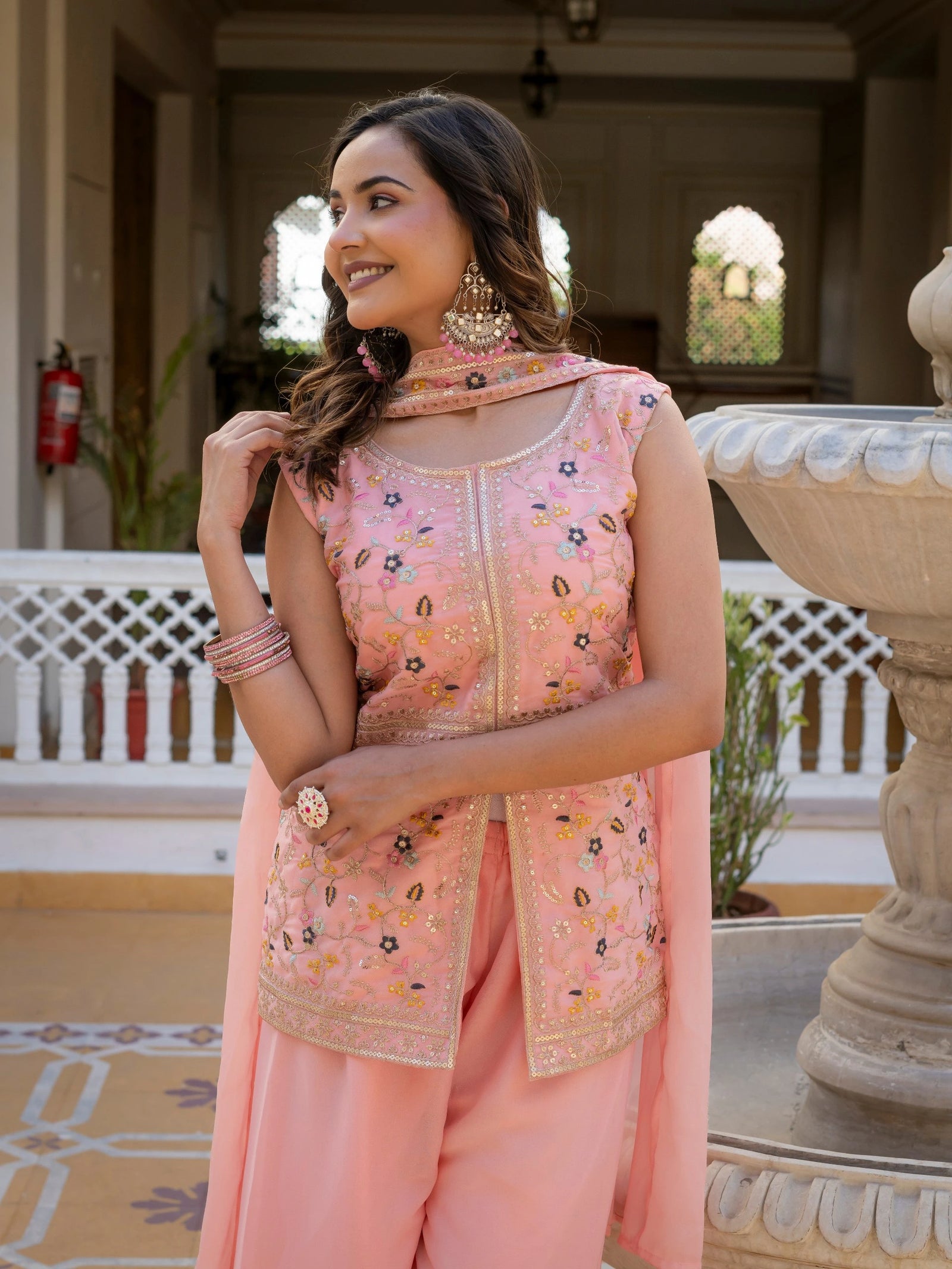 Stylish light pink georgette suit with heavy embroidery on sleeves and hemline.