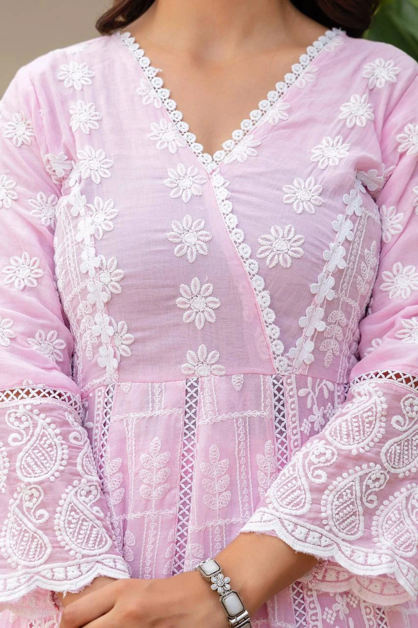 Close-up of a pink embroidered garment with white floral patterns