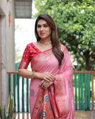 Woman wearing a pink saree with a decorative pattern, standing outdoors.