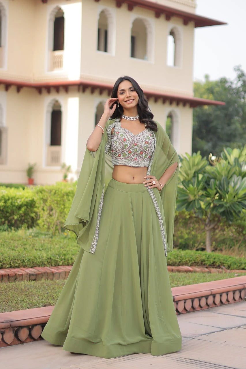 Woman in a green traditional outfit standing outdoors with a building in the background