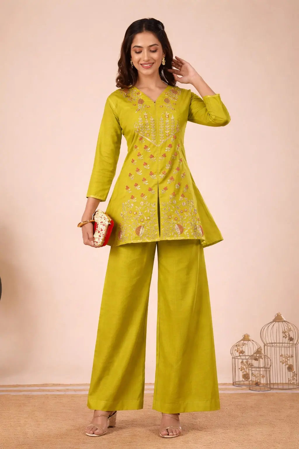 Woman wearing a green traditional outfit with a matching handbag against a beige background