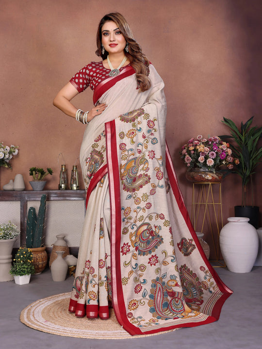 Woman wearing a white saree with red border and floral patterns in a decorated room.