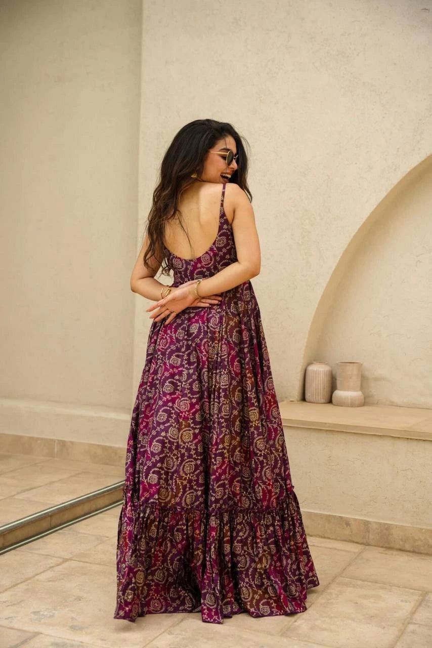 Woman wearing a patterned dress standing in a room with a neutral color scheme.