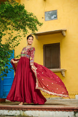 Woman in a red traditional outfit standing in front of a yellow wall with a blue door.