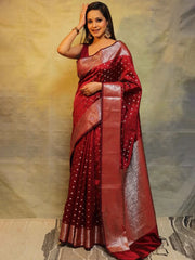 Woman wearing a red saree with a gold border against a neutral background
