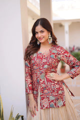 Woman wearing a patterned red and beige traditional outfit with jewelry, standing outdoors.