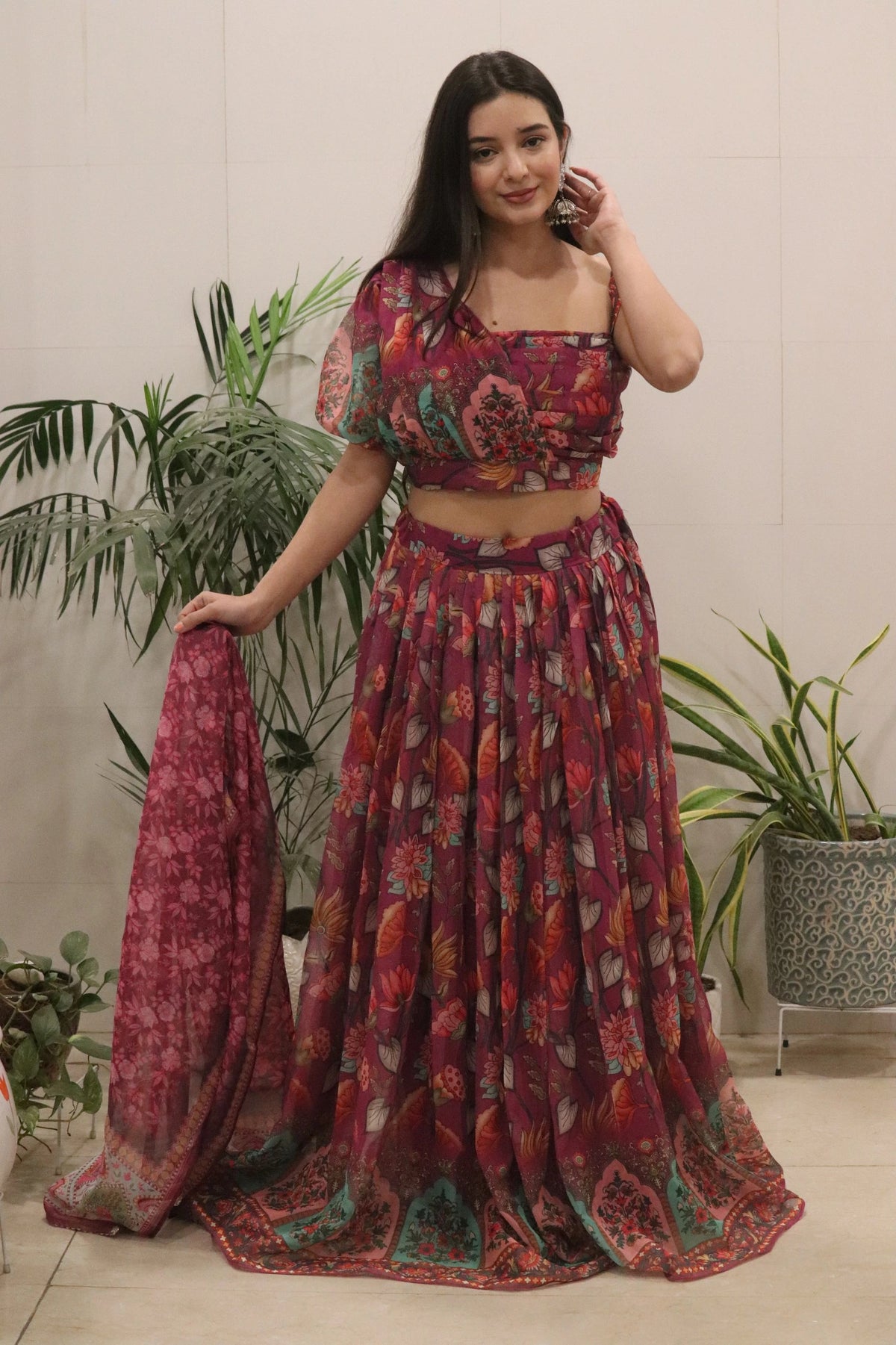 Woman wearing a patterned outfit with plants in the background