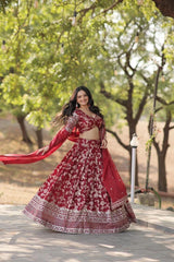 Woman in a red and white traditional outfit standing outdoors with trees in the background
