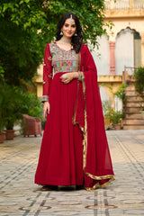Woman in a red traditional outfit with embroidery standing outdoors.